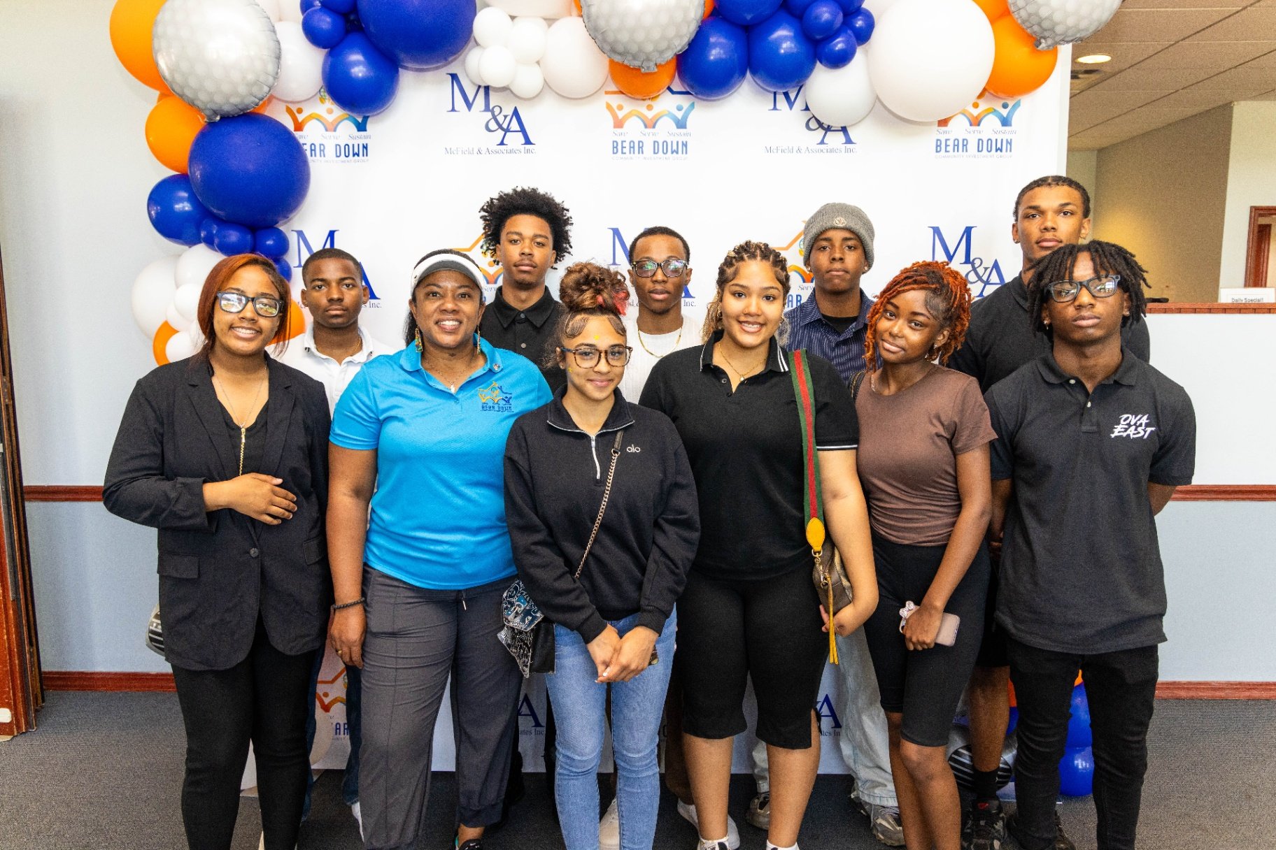 Bear Down team and community partners gathered at the M&A event backdrop